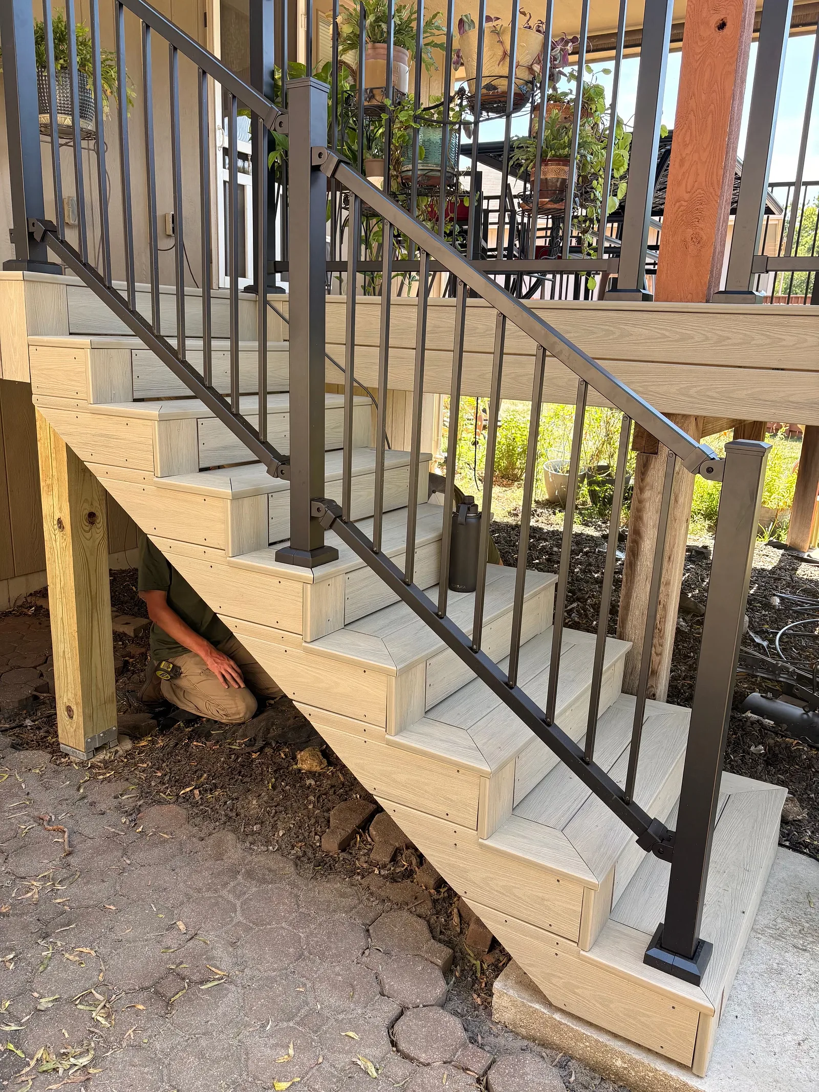 Composite stairs Wood-look composite deck stairs with black metal railing in Topeka, KS