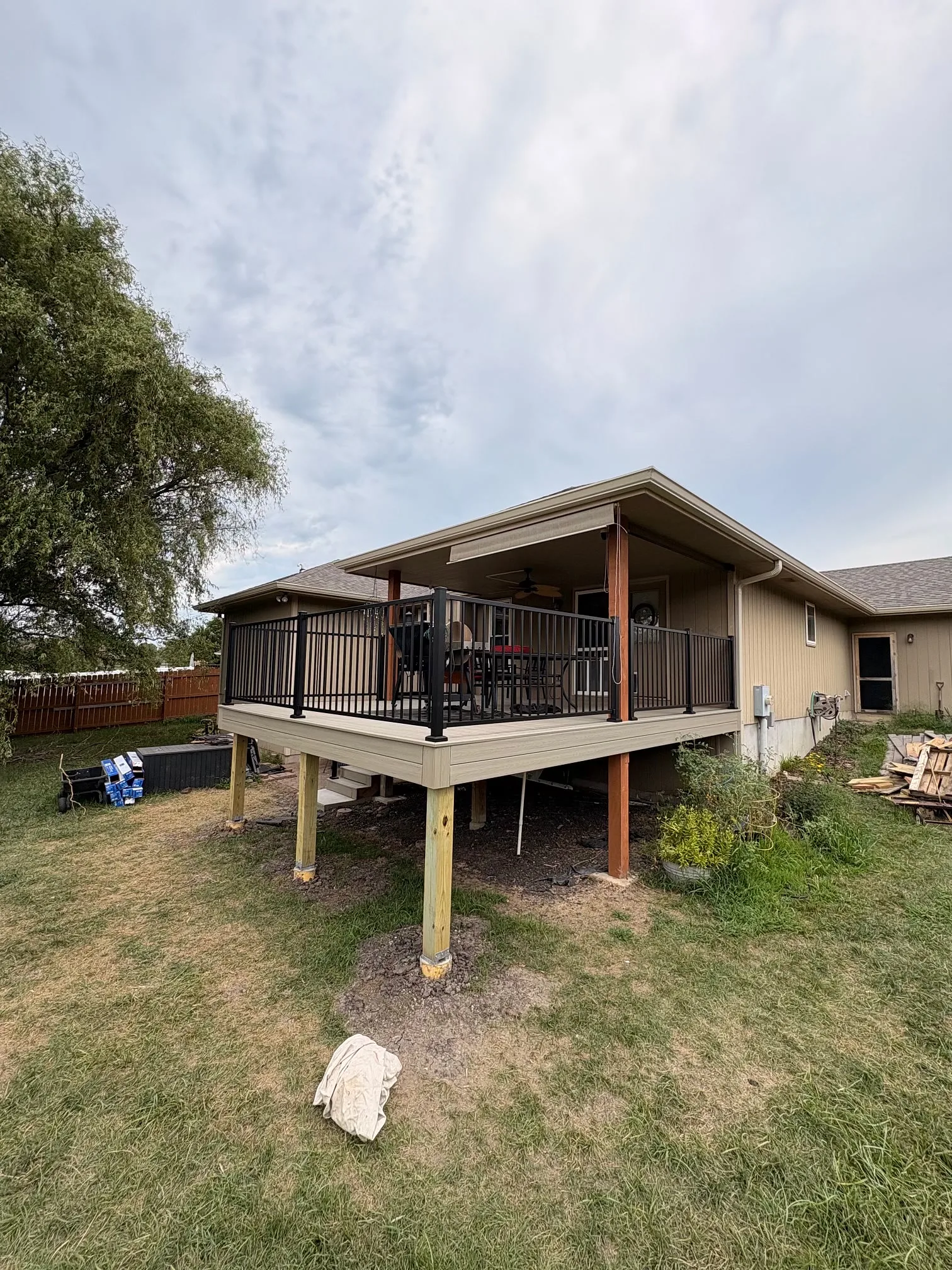 Covered Elevated Deck Covered elevated backyard deck with black metal railing built by Kingdom Builders Co. in Topeka, KS