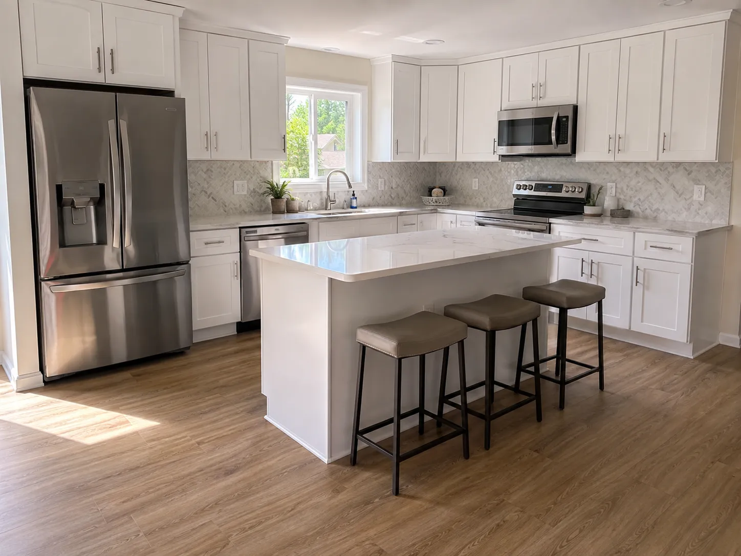 White shaker kitchen with quartz island, Topeka KS White shaker kitchen remodel in Topeka, KS with a quartz island and herringbone backsplash